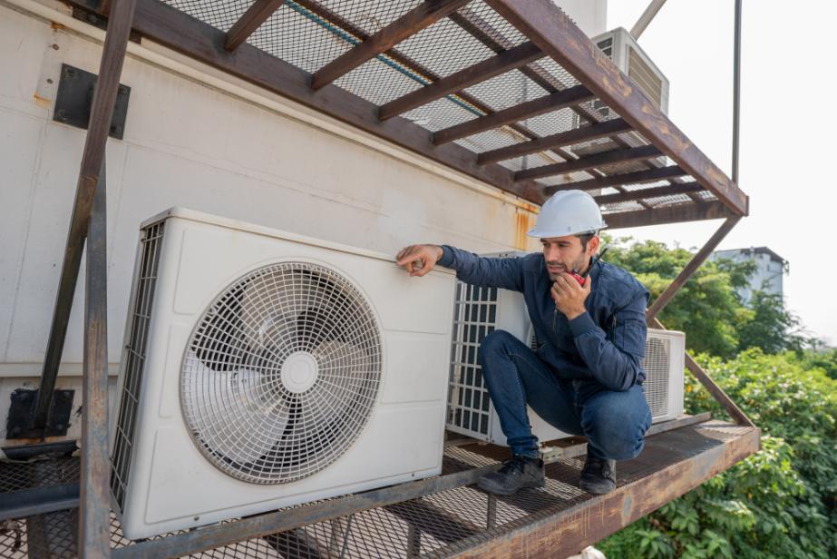 HVAC technician inspecting outdoor unit