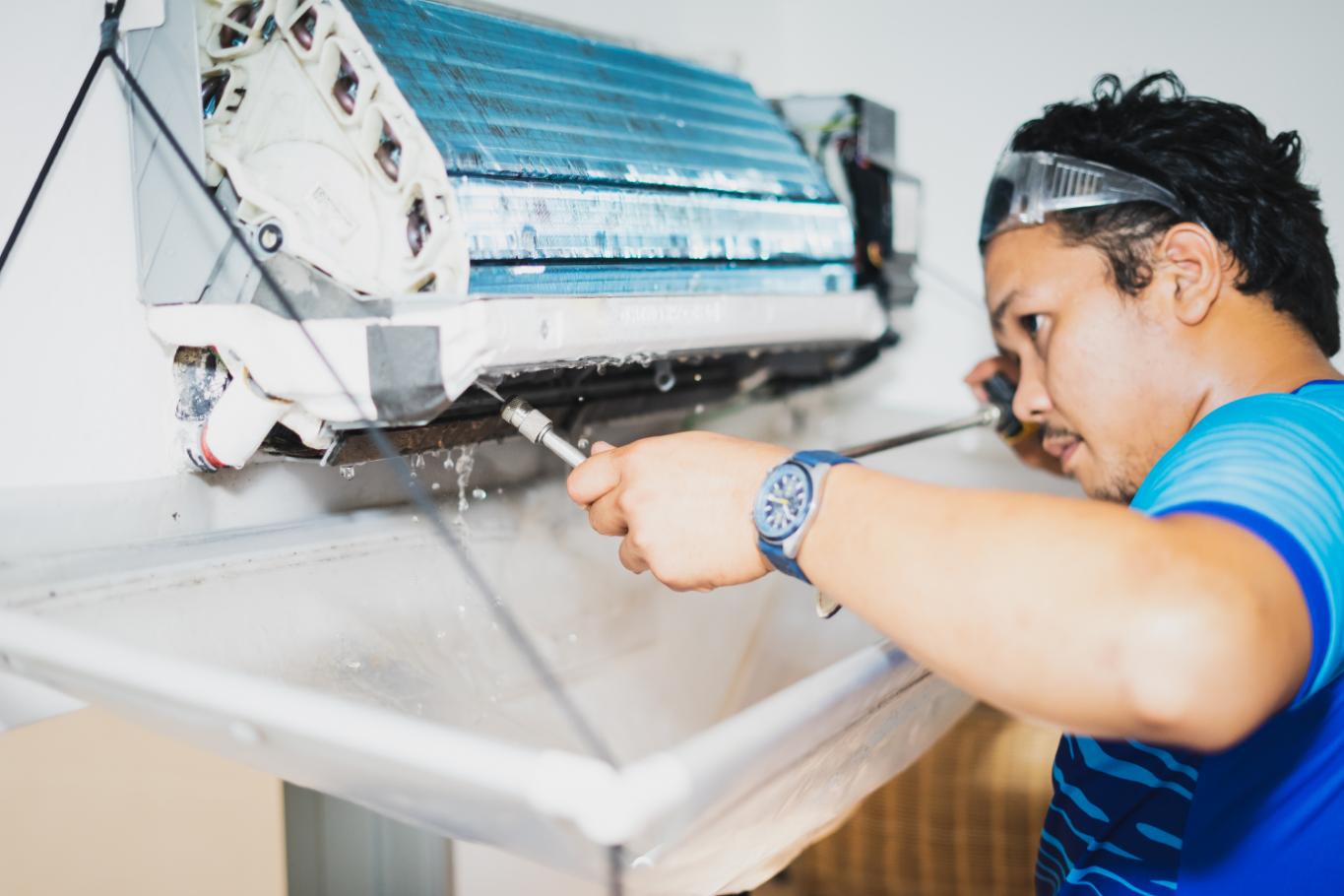 Technician cleaning indoor AC unit